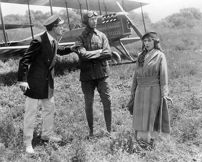 Mary Pickford stands in front of a plane in 1915's The Girl from Yesterday.