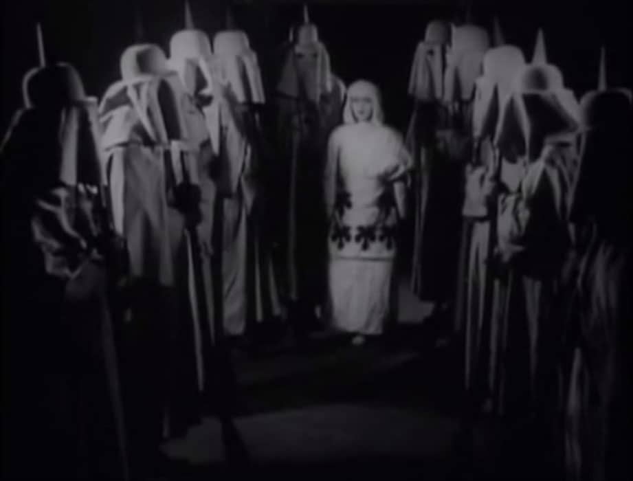A woman in white is surrounded by hooded Danites in A Mormon Maid (1917) a more outlandish Mormon exploitation film.